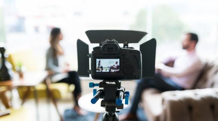 Business leaders: The message is your business Reporter interviewing businessman seen on video camera display at office