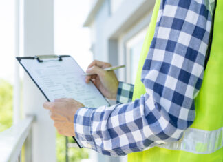 What’s new and exciting at Tarion and HCRA? inspector or engineer is inspecting construction and quality assurance new house using a checklist. Engineers or architects or contactor work to build the house before handing it over to the homeowner