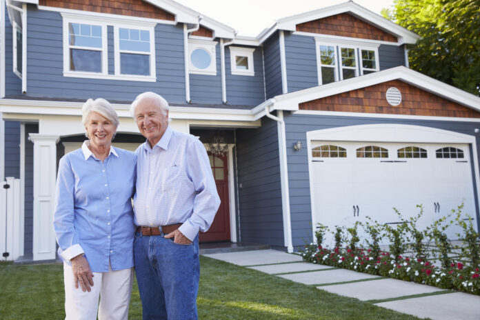 Portrait Of Senior Couple Standing Outside House Portrait Of Senior Couple Standing Outside House